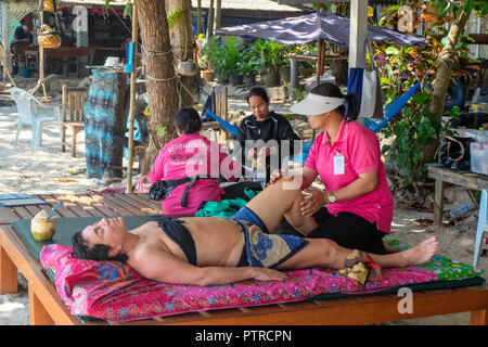 Ko Samed, Thailand - December 19, 2017. Visitor enjoying a Thai massage on the beach Stock Photo