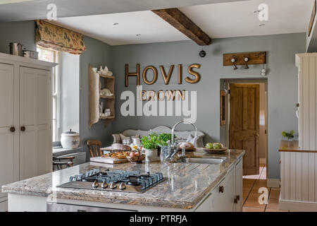'HOVIS' lettering in kitchen with gas hob fitted to island unit in restored 16th century farmhouse Stock Photo
