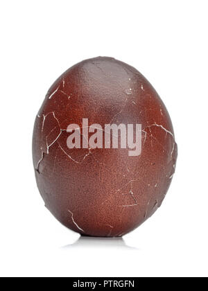 Dark brown egg with cracked egg shell on white background Stock Photo