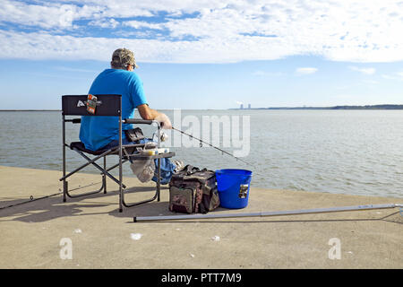 Fairport Harbor, Ohio, USA, 10th Oct, 2018.  A man fishes in Fairport Harbor with a view of the Perry Nuclear Power plant in the distance.  Record-high temperatures this week in Northeast Ohio has extended summer bringing people outdoors to enjoy the last blast of summer.  Monday's weather in Cleveland hit an all-time high of 89(f) degrees, Tuesday tied the record high, and today saw the temperatures near historic highs with the high reaching 85(f).  The typical early October high temperature is in the mid-60's.  Credit: Mark Kanning/Alamy Live News. Stock Photo