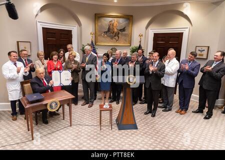 Washington DC, USA. 10th Oct 2018. U.S President Donald Trump holds up the signed S. 2553- the Know the Lowest Price Act and S.2553- the Patients Right to Know Act following a signing ceremony in the Roosevelt Room of the White House October 10, 2018 Washington, DC. Credit: Planetpix/Alamy Live News Stock Photo