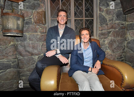 Potsdam, Brandenburg. 11th Oct, 2018. The actors James (r) and Oliver Phelps who sit in the Harry Potter films The Weasley Twins at the press conference for the 'Harry Potter' exhibition in the set of Hagrid's hut. The exhibition, which opens for visitors on Saturday (13.10.2018) in the Filmpark Babelsberg, shows costumes and complete sets of the film series. Credit: Bernd Settnik/dpa-Zentralbild/dpa/Alamy Live News Stock Photo