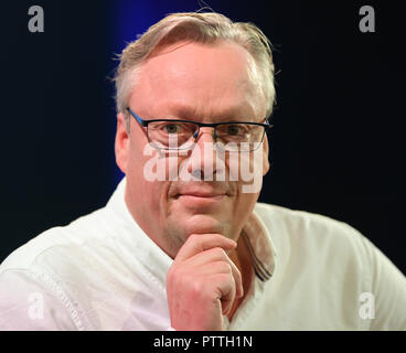 Frankfurt, Germany. 11th October, 2018. 11 October 2018, Hessen, Frankfurt Main: The Swedish bestselling author Jonas Jonasson looks into the camera after his performance on the 'Blue Sofa' of ZDF. The world's largest book show takes place until 14 October. Photo: Arne Dedert/dpa Credit: dpa picture alliance/Alamy Live News Stock Photo