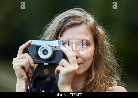 Woman photographer with vintage film camera taking photos outdoor Stock Photo