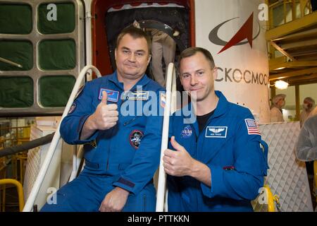 Expedition 57 crew member cosmonaut Alexey Ovchinin of Roscosmos, left, and Nick Hague of NASA pose in front of the Soyuz MS-10 spaceship in their blue jump suits at the Baikonur Cosmodrome October 6, 2018 in Baikonur, Kazakhstan. The two are scheduled to launch on October 11th and will spend the next six months living and working aboard the International Space Station. Stock Photo