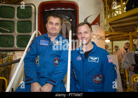 Expedition 57 crew member cosmonaut Alexey Ovchinin of Roscosmos, left, and Nick Hague of NASA pose in front of the Soyuz MS-10 spaceship in their blue jump suits at the Baikonur Cosmodrome October 6, 2018 in Baikonur, Kazakhstan. The two are scheduled to launch on October 11th and will spend the next six months living and working aboard the International Space Station. Stock Photo