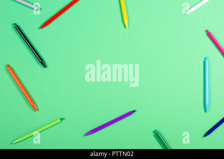 Colorful pens frame on green background Stock Photo