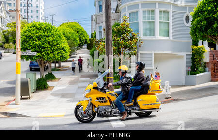 A beautiful yellow motorcycle pauses in Pacific Heights in San Francisco outside the house where Mrs Doubtfire was filmed Stock Photo