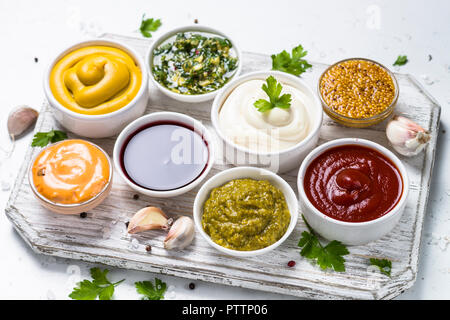 Set of sauces - ketchup, mayonnaise, mustard soy sauce, bbq sauce, pesto, chimichurri, mustard grains and pomegranate sauce on white background. Stock Photo
