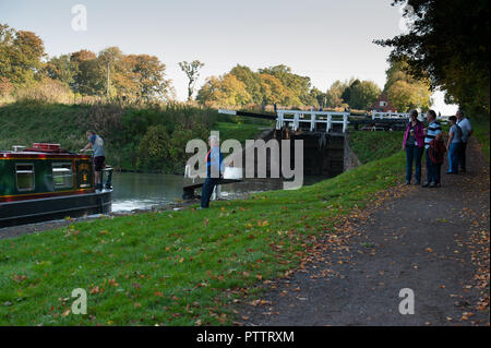 'Gonggozlers' watching Volunteer Lock Keepers helping a narrowboat through the Caen Hill Flight on the Kennet and Avon Canal, Devizes, Wiltshire, UK. Stock Photo