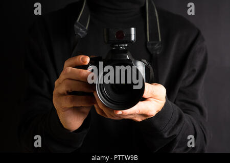 Person holding a DSLR camera close up Stock Photo