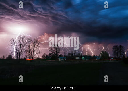 Thunderstorm at night over small village Stock Photo