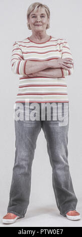 Seniorin in Jeans und Pulli, verschraenkte Arme (model-released)