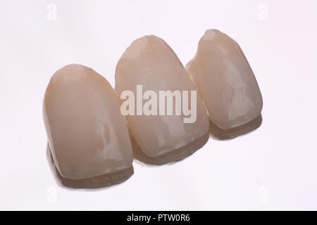 dental ceramic veneers and crowns isolated with mirror background. Stock Photo