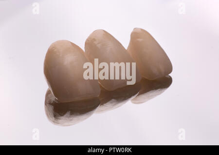 dental ceramic veneers and crowns isolated with mirror background. Stock Photo