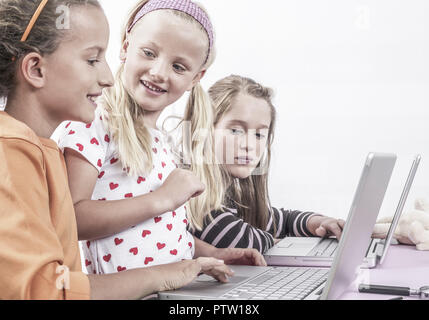 Drei Maedchen arbeiten mit Laptop (model-released)