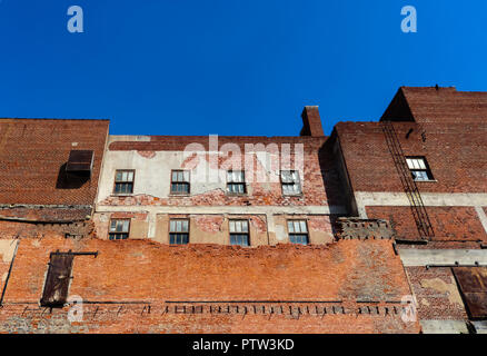 Old grungy brick building that has been partially torn down and is being rebuilt but is still very rough Stock Photo
