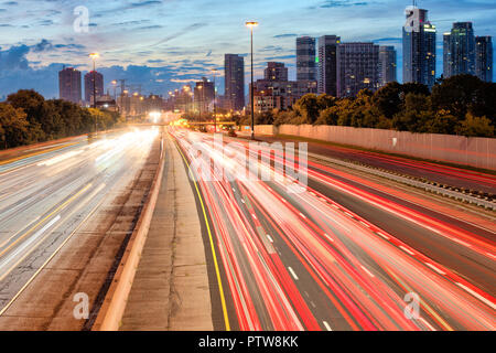 Highway  Gardiner Expressway in Toronto Ontario with tail lights and buildings at dawn before sunrise Stock Photo