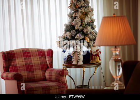 Santa claus holding gift box at home,Sit on chair think about plan for sent gift box for give children Stock Photo