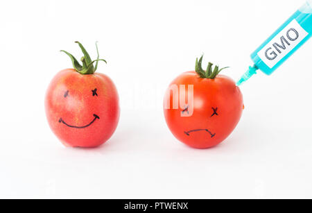 Tomatoes on a white background with faces in which are pricked from a syringe gmo and nitrates, close-up, genetically Stock Photo