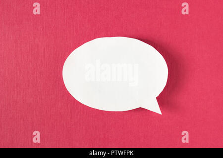 White bubble message from a paper on a red background, social network, symbol Stock Photo