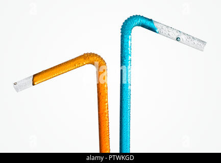 Two plastic drinking straws with orange and blue liquid, studio shot Stock Photo