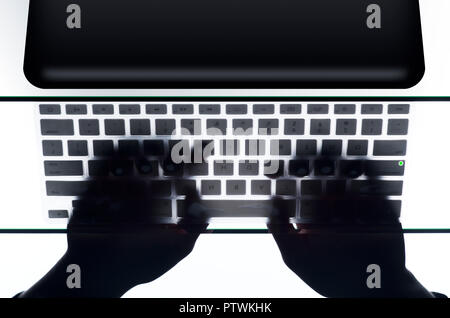 Person using laptop and typing on keyboard, high angle view Stock Photo
