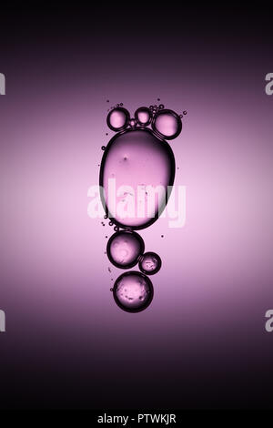 Transparent bubbles floating in liquid, purple background Stock Photo