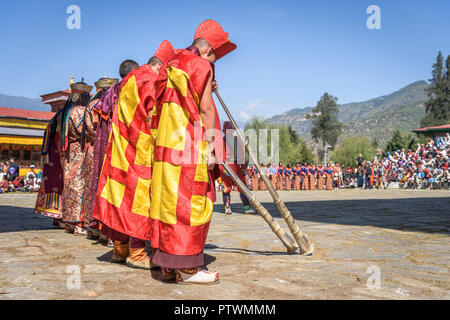 Monks making music with trumpets for colorful mask dance at yearly Paro Tsechu festival in Bhutan Stock Photo