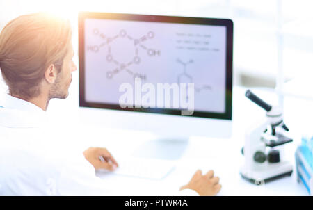 Young man working in a medical lab using a computer Stock Photo