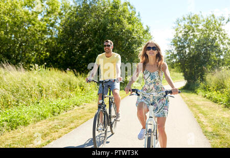 happy young couple riding bicycles in summer Stock Photo