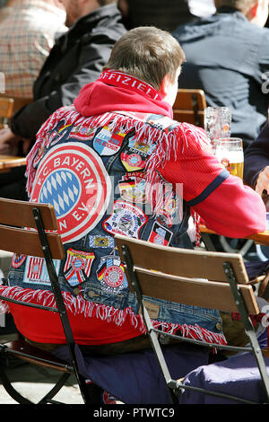 Bayern Munich football supporter quietly enjoying a beer in Munich centre market prior to the game. Stock Photo