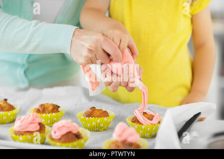 mother and daughter cooking cupcakes at home Stock Photo