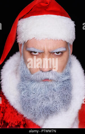 evil Santa Claus  angrily looks at the camera on a dark background Stock Photo