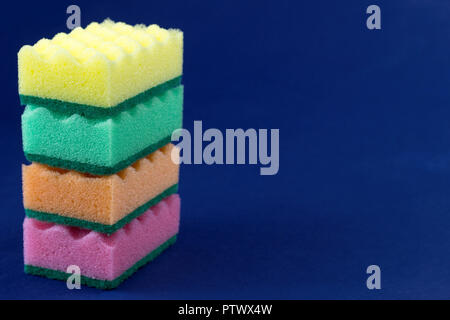 multicolored sponges for washing on a blue background Stock Photo