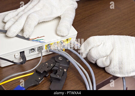 A man connects a network cable to the modem, a close-up Stock Photo