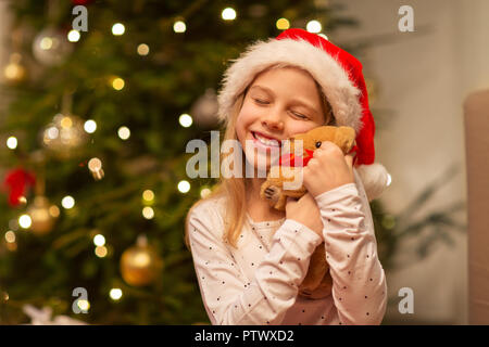 smiling girl in santa hat with christmas gift Stock Photo