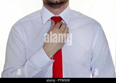 Bearded man in a white shirt with a red tie on a white background, close-up Stock Photo