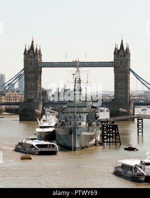 Royal Navy warship HMS Belfast moored on the River Thames in front of Tower Bridge, London, England. Stock Photo