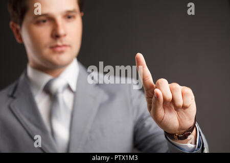 business, technology, internet and networking concept - businessman pressing button with contact on virtual screens. Stock Photo