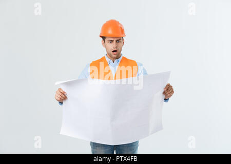 Thoughtful architect holding blueprints against white background Stock Photo