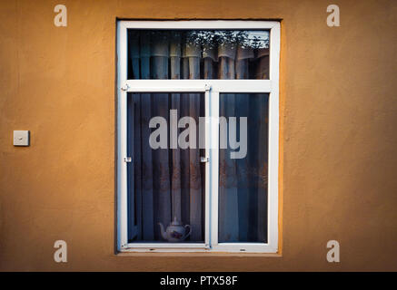 An open window with a mosquito net in the wall of the country house Stock Photo