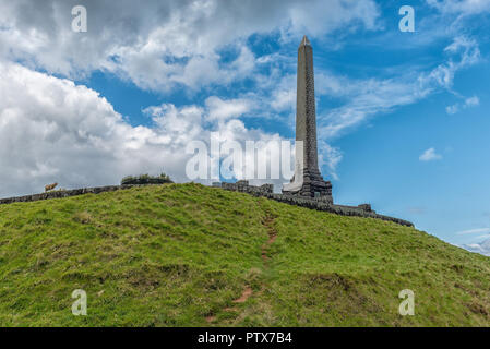 Obelisk on top of one tree hill in auckland against a blue sky with clouds Stock Photo