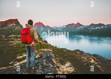 Discoverer tourist man trekking in sunset mountains Traveling lifestyle adventure concept hiking with red backpack wanderlust vacations outdoor Stock Photo