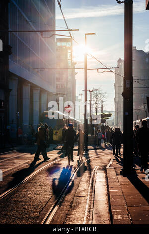 A shot of the mix of transport options in the Northern Powerhouse of Manchester. Hazy day and backlit commuters. Stock Photo