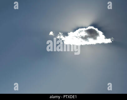 Sun Shining Behind a Single small cloud Stock Photo