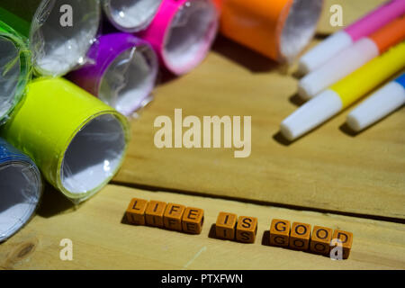 Life is good on wooden cubes with colorful paper and pen, Concept Inspiration on wooden background Stock Photo