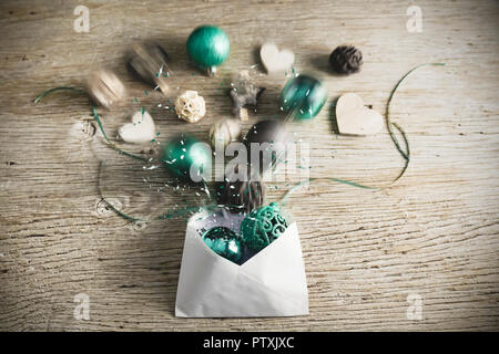 A letter for Christmas is opened. The turquoise colored christmas balls and wooden elements splash out. Happy message for Christmas. Stock Photo