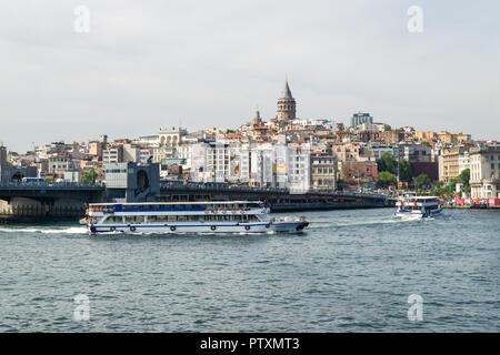 View towards Karakoy with Galata bridge and Galata tower as ferries sail past on the Bosphorus strait, Istanbul, Turkey Stock Photo