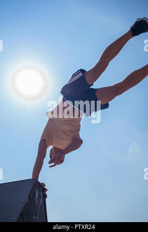 Yound healthy man doing handstand in skatepark Stock Photo